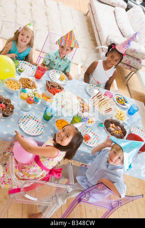 I bambini a parte seduta a tavola con cibi sorridente Foto Stock