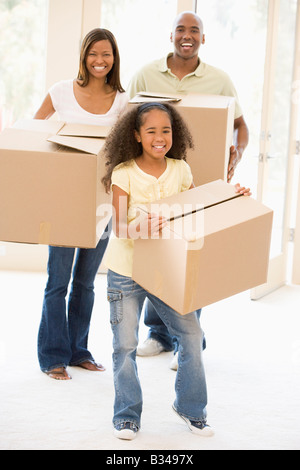 Famiglia in movimento nella nuova casa sorridente Foto Stock