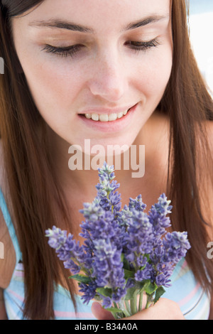 Donna che mantiene i fiori Foto Stock