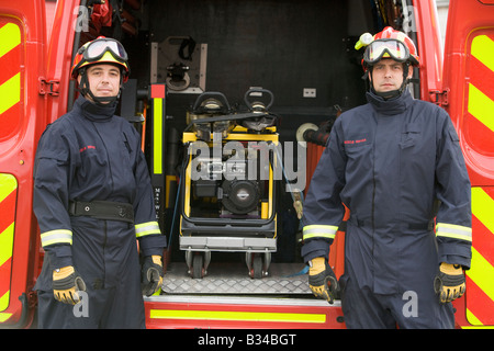 Due squadre di soccorso in piedi da aprire lo sportello posteriore del veicolo di soccorso Foto Stock