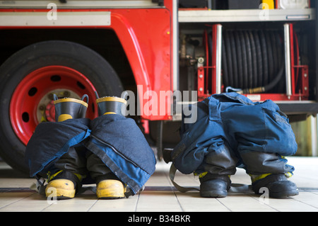 Due mezzi antincendio uniformi sul pavimento da motore Fire Foto Stock