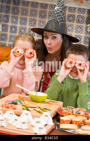 Madre e i due figli di Halloween a giocare con la tratta e sorridente Foto Stock
