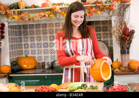 Donna carving jack o lanterna di Halloween e sorridente Foto Stock