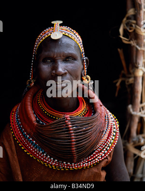 Kenya, frontiera settentrionale distretto, Loyangalani. Una donna Turkana, tipicamente indossando molti strati di collane di perle e una serie di orecchini a cerchio con una coppia di foglie-earrrings sagomato nella parte anteriore. Foto Stock