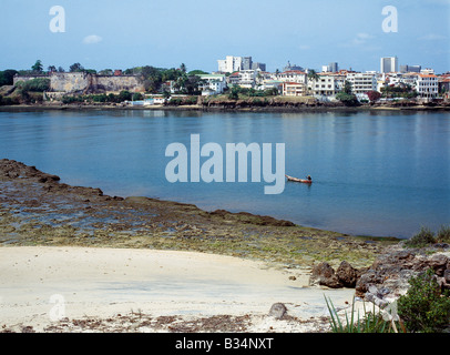 Kenya, Costa, Mombasa. Un pescatore in una piroga canoa Pagaie passato Fort Jesus e la città vecchia di Mombasa. Foto Stock