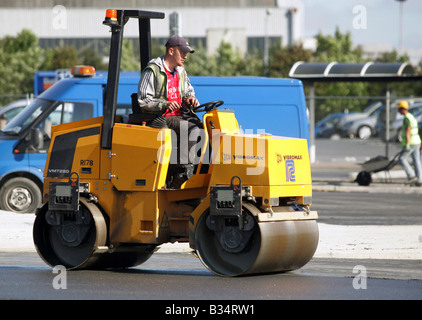 Un lavoratore edile in un rullo su strada, Dublino, Irlanda Foto Stock