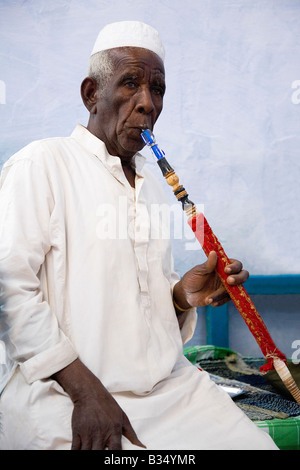 Il vecchio uomo egiziano di fumare narghilè tubazione acqua Nubia Aswan Egitto Nord Africa Foto Stock