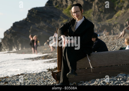 Nigun ortodosso ebrei indossando abiti tradizionali nel periodo delle vacanze estive sulla spiaggia in Aberystwyth Wales UK Foto Stock