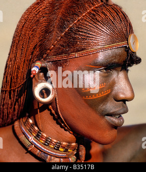 Kenya, Maralal, Maralal. Un Samburu Warrior risplende con lunghi, intrecciato Ochred capelli. Il round orecchio ornamenti dei guerrieri sono realizzate in avorio. Samburu warriors sono vane e orgogliosi, prendendo in grande difficoltà oltre il loro aspetto. Ocra è una terra naturale contenente ossido ferrico che è mescolato con grassi animali per la coerenza di greasepaint. Foto Stock