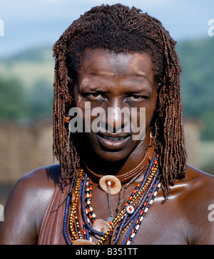 Kenya, Trans-Mara, Lolgorien. Un guerriero Masai risplendente con lunghe trecce ochred. Il suo corpo è stato cosparso con ocra rossa mescolato con grasso animale mentre le parti del suo volto sono stati ricoperti di polvere ocra. Foto Stock