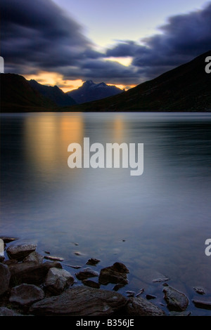 Un pre alba rappresentazione del Nivolet lago alpino lago glaciale nel cuore del Parco Nazionale del Gran Paradiso in Italia Foto Stock