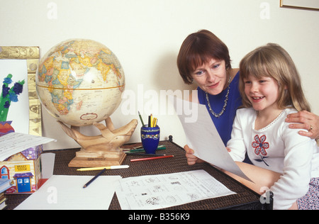 Madre facendo compiti a casa con la figlia Foto Stock