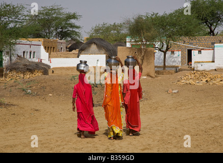 BANJARI TRIBESWOMEN portare acqua nel loro villaggio nel deserto di Thar vicino a Jaisalmer Rajasthan in India Foto Stock