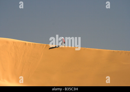 Uomo solitario a piedi su una duna di sabbia in Akachaker Tassili Ahaggar deserto del Sahara Algeria Foto Stock