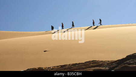 Persone a piedi su una duna di sabbia in Akachaker Tassili Ahaggar deserto del Sahara Algeria Foto Stock