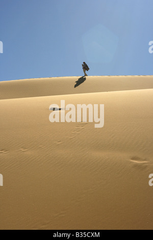 Persona che cammina su una duna di sabbia in Akachaker Tassili Ahaggar deserto del Sahara Algeria Foto Stock