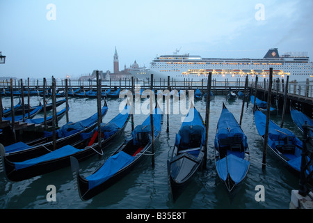 Gondole e una nave passeggeri al crepuscolo, Venezia, Italia Foto Stock