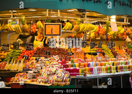 Spagna Barcellona fornitore femmina vendere frutta e bevande di frutta in stallo in La Boqueria produrre i prezzi di mercato in euro Foto Stock