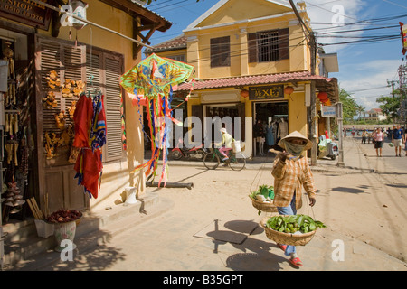 Una donna di capi per il mercato giornaliero in Hoi An, Vietnam Foto Stock