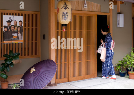 Una maiko o apprendista geisha penetra nel suo okiya residence in Gion hanamachi distretto della città di Kyoto Foto Stock