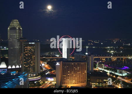 Lo skyline di Singapore di notte sul lato del porto e Esplanade con una luna piena , Singapore Sud Est asiatico Foto Stock
