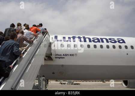 Commerciale viaggi dell'aria. I passeggeri di salire a bordo di un Lufthansa Airbus A321 aereo di linea per mezzo di una scala mobile o di una rampa di scale Foto Stock