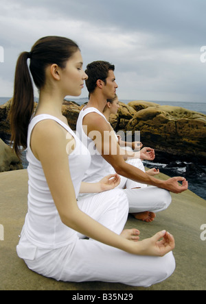 Profilo laterale di due giovani donne e due giovani uomini a praticare yoga Foto Stock