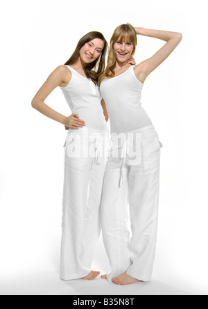 Ritratto di due giovani donne in piedi con le braccia intorno e sorridente Foto Stock