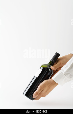 Uomo che mostra la bottiglia di vino, vista ritagliata delle mani Foto Stock