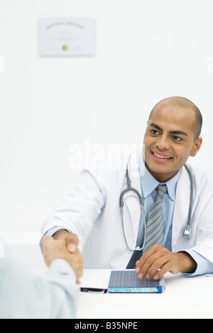 Medico stringono le mani con paziente, al di sopra della spalla Foto Stock