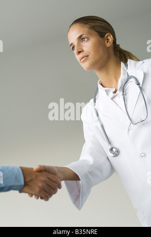 Medico donna uomo agitando la mano e a basso angolo di visione, ritagliato Foto Stock