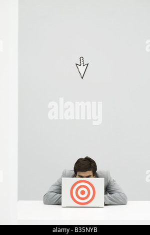 Computer di puntamento del cursore a imprenditore nascondersi dietro a target Foto Stock