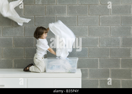 Little Boy giocando con lavanderia, sorridente, vista laterale Foto Stock