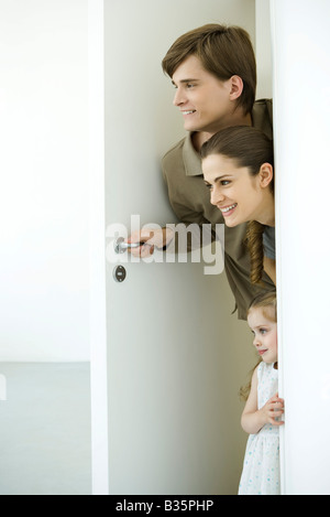 Famiglia peeking in porta Foto Stock