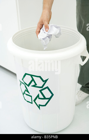 Uomo di gettare la carta stropicciata nel contenitore di riciclaggio, vista ritagliata Foto Stock