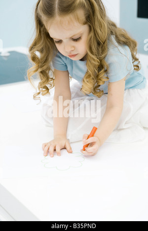 Bambina disegno con pastelli, guardando verso il basso Foto Stock