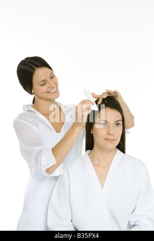 Hair stylist pettinatura donna capelli, sia cercando di distanza Foto Stock