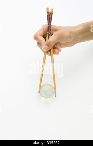 Mani con bacchette per tenere globo trasparente, vista ritagliata Foto Stock