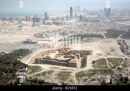 Foto aerea del Bahrain Fort noto anche come fortezza Portoghese o Qal'at al-Bahrain con lo skyline di Manama in background. Foto Stock