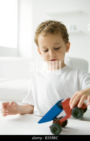 Little Boy giocando con il giocattolo autocarro con pianale di scarico Foto Stock