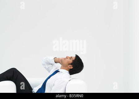 Professional reclinabili uomo in poltrona, testa indietro, sul telefono Foto Stock