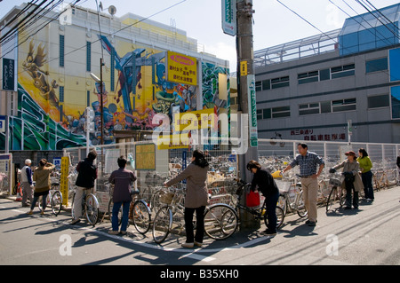 Linea di persone intorno a una bicicletta-parcheggio Foto Stock