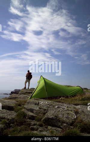 Tenda verde sulla scogliera che si affaccia sul mare con walker. Foto Stock