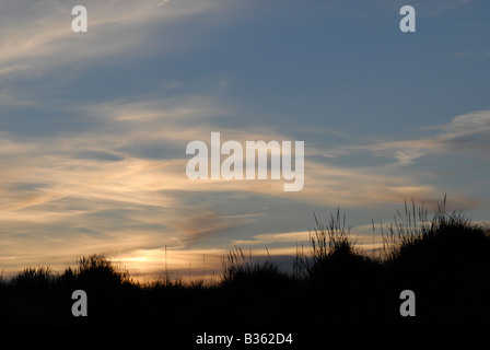 Sole che tramonta dietro le dune di sabbia sulla spiaggia Talacre nel Galles del Nord Foto Stock