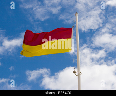 RNLI rosso e giallo di bandiera per denotare safe area nuoto, England, Regno Unito Foto Stock