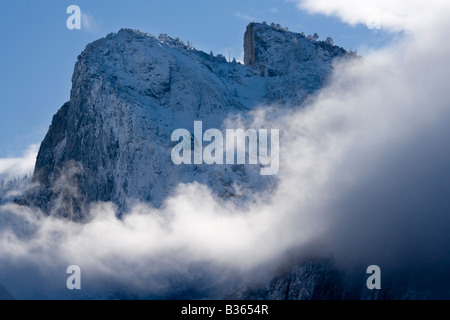 Cathedral Rocks emerge dalle nubi di una notte di tempesta di neve nel Parco Nazionale di Yosemite in California USA Foto Stock