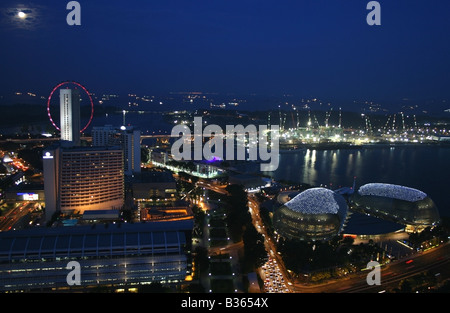 Lo skyline di Singapore di notte sul lato del porto e Esplanade con una luna piena , Singapore Sud Est asiatico Foto Stock