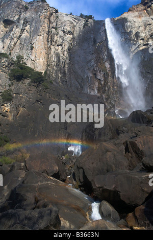 Un arcobaleno forme nella nebbia alla base di Bridalveil Falls Yosemite National Park California USA Foto Stock