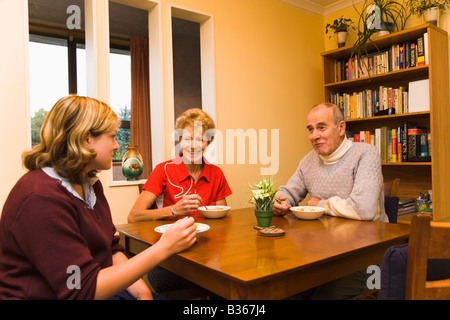Famiglia avente pasto nella sala da pranzo Foto Stock