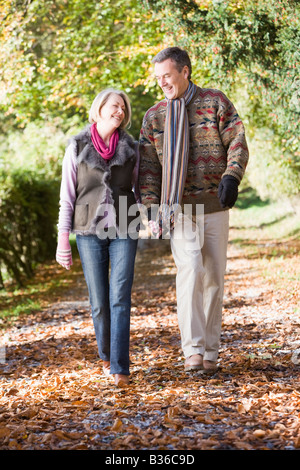 Giovane all'aperto camminando sul percorso nel parco si tengono per mano e sorridente (messa a fuoco selettiva) Foto Stock